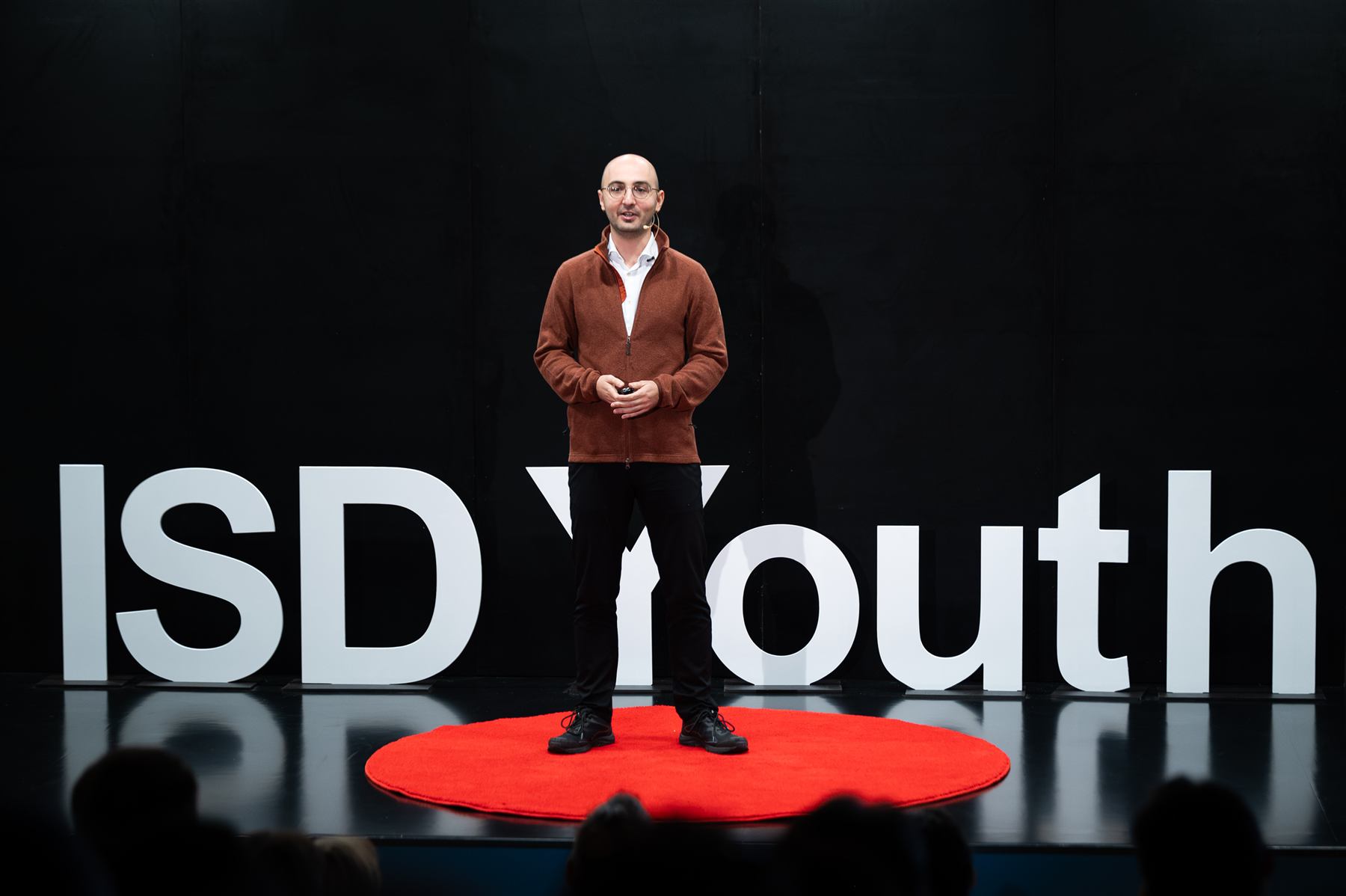 A speaker delivering his talk on the red circle mark